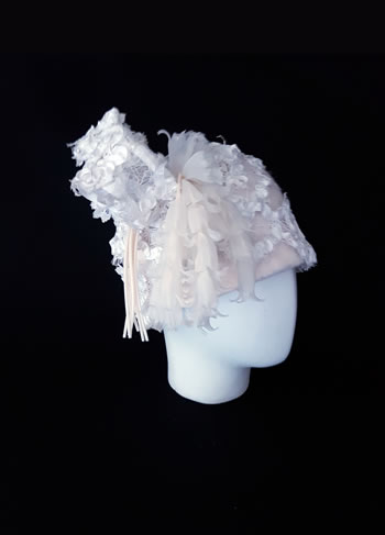 Sombrero de fieltro adornado con estructura alambrada de encaje bordado y flores de seda hechas a mano